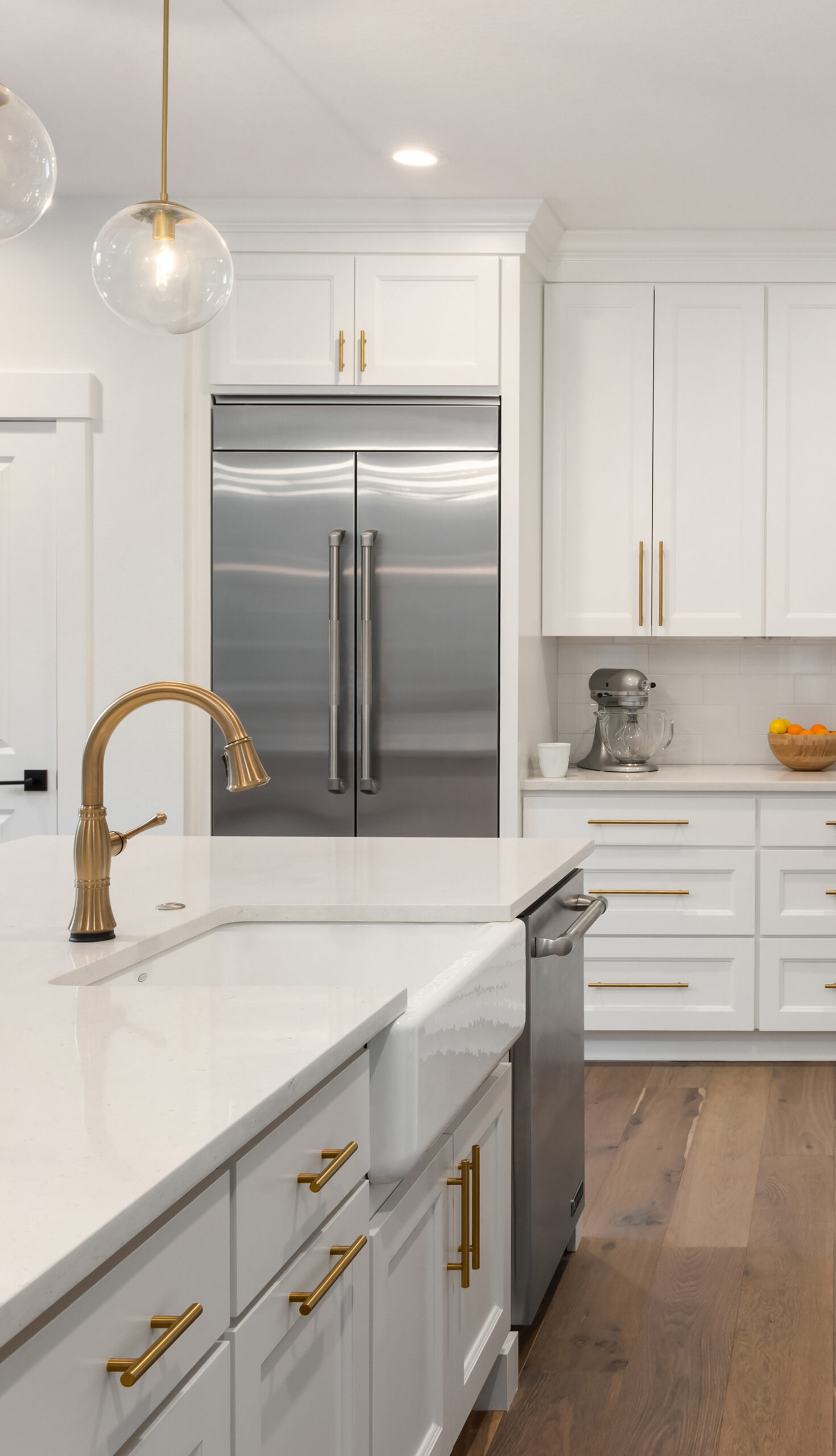 beautiful kitchen in new luxury home with island, pendant lights