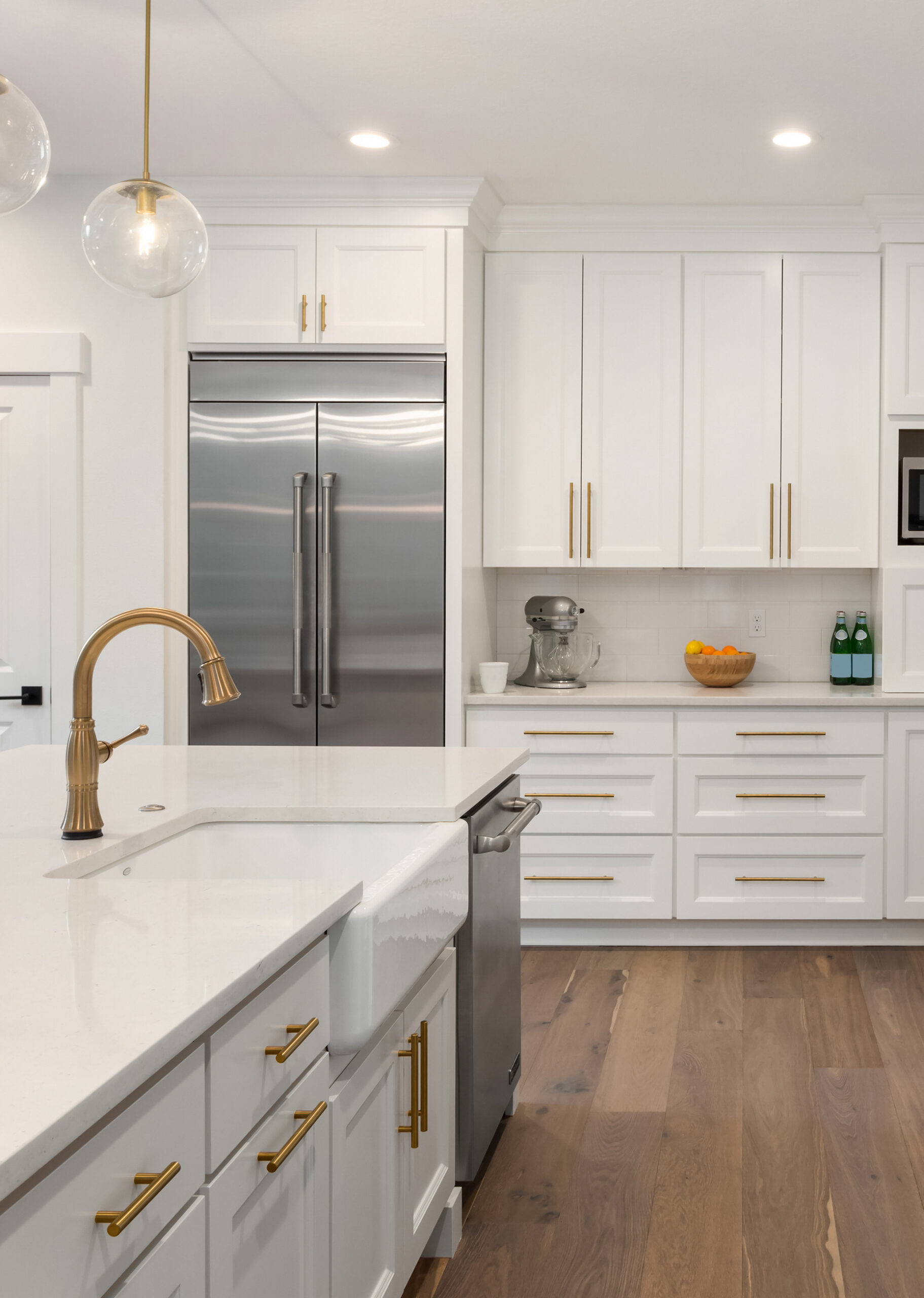 beautiful kitchen in new luxury home with island, pendant lights